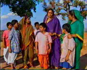 Una multitud de aldeanos marcha a la casa de Patel. Todos ellos están enojados y molestos por lo que Young Sai está haciendo. Uno de ellos llama a la puerta de la casa de Patel.