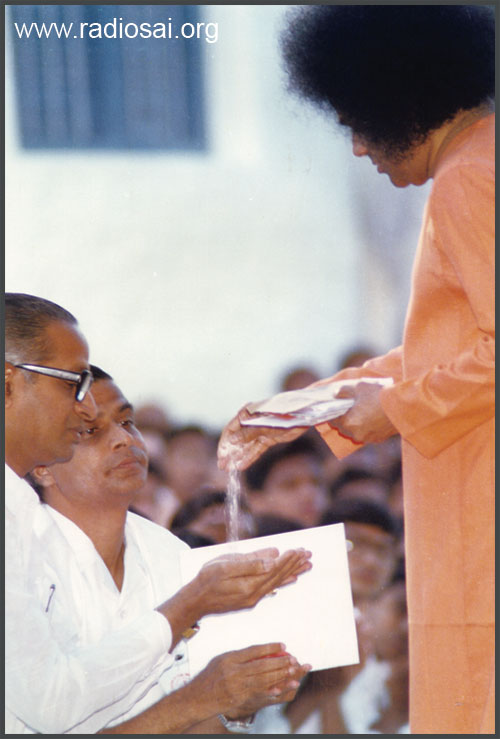 sathya sai baba giving vibhuti to devotess